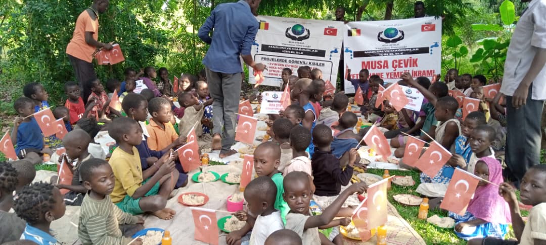 Children seated together during a community feeding program